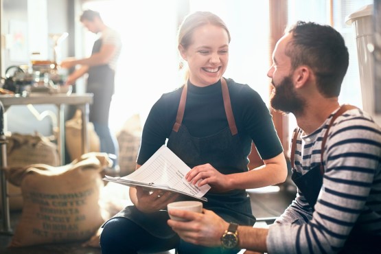 Three people discussing while having coffee